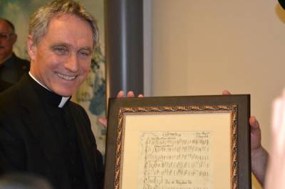Erzbischof Gnswein mit seinem Geschenk, ein historisches Notenblatt aus dem Chiemgau